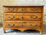 a wooden chest of drawers on a tiled floor