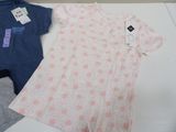 two baby clothes sitting on a table next to each other