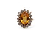 un gros plan d'une bague ornée d'une grosse citrine entourée de petits diamants