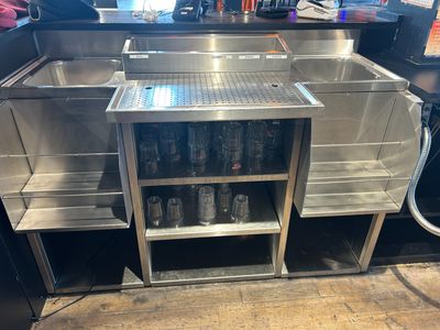 a stainless steel sink in the middle of a kitchen