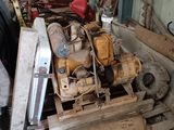 un tas de vieilles machines dans un garage, à côté d'un tas de bois