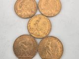four gold coins sitting on top of each other on a white surface