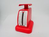 une image représentant une balance rouge posée sur une table blanche