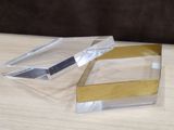 pair of clear and gold acrylic boxes sitting on a wooden table