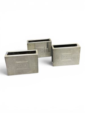 three cement planters are sitting next to each other on a white surface