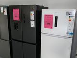 several refrigerators are lined up in a row in a room