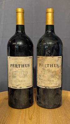 two bottles of wine sitting on a table next to each other