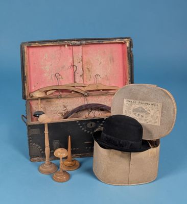 une vieille valise sur laquelle est posé un chapeau
