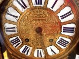a gold clock with black and white roman numerals on it