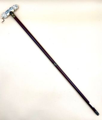 a close up of a metal stick with a handle on a white surface