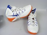 pair of white and blue shoes with orange soles on a white surface