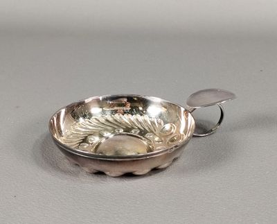 un bol en argent avec une cuillère sur une table