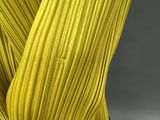 a close up of a woman ' s legs wearing a yellow plea skirt