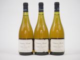trois bouteilles de vin blanc posées les unes à côté des autres sur une table