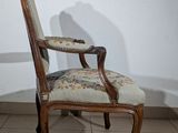 a chair with a floral upholstered seat on a tiled floor