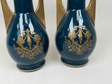 pair of blue vases with gold decoration on them on a white surface