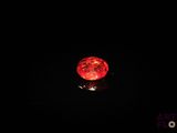 une image représentant une balle rouge dans l'obscurité, sur fond noir