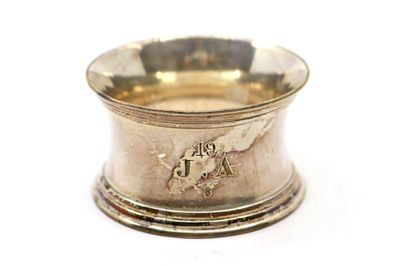 une tasse en argent posée sur une surface blanche