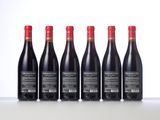 six bottles of red wine lined up in a row