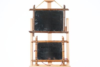 a wooden shelf with two chalkboards on it