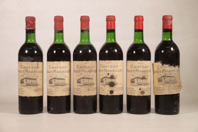 quatre bouteilles de vin sont alignées sur une table