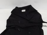 the back of a black jacket with buttons on it sitting on top of a white surface