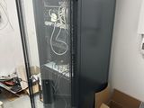 une armoire noire avec une porte vitrée au milieu d'une pièce