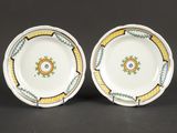 deux assiettes ornées de motifs jaunes et verts sur un fond noir