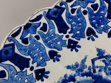 a blue and white plate with a bird and flowers on it