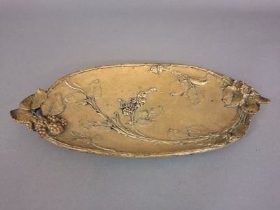 an image of a gold plate with flowers and leaves on it