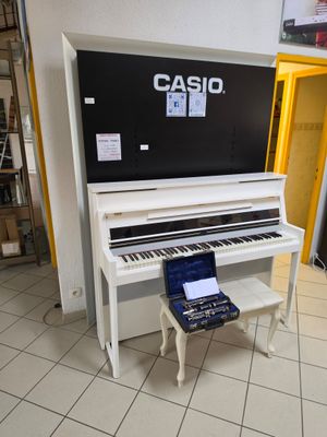 un piano posé dans une pièce, sur un support de piano