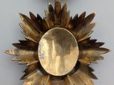 a gold medal with a crown on top of it