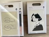 two boxes with drawings on them sitting on a wooden table