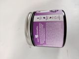 a jar of purple colored cream sitting on a table