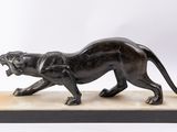 a bronze statue of a panther on a marble base