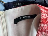 the jacket is hanging on the clothes rack in the closet