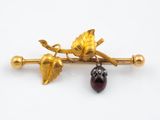 une image représentant une broche en or et en grenat ornée de feuilles