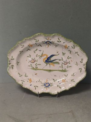 a plate with a bird on it on a stand