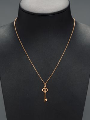 a gold key necklace on a mannequin mannequin mannequin mannequin mannequin mannequin mannequin mannequin manne