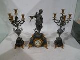trois bougies et une horloge exposées dans une vitrine