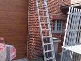 une échelle appuyée contre un mur de briques, à côté d'une table