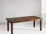 La table est en bois et présente un motif géométrique.