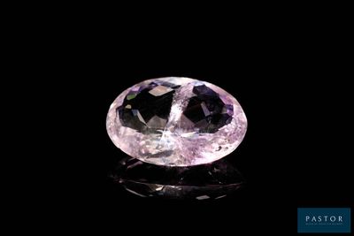 a close up of a pink diamond on a black surface