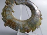 a green and gold piece of art on a clear stand