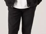 the man is wearing a white t - shirt, black jeans, and a black denim jacket