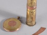 un petit objet en laiton posé à côté d'un couteau et d'une pièce de monnaie