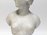 white marble bust of a woman with braids on her hair
