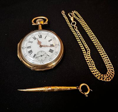a gold pocket watch and a chain on a black surface