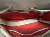a white purse with a red lining inside of it