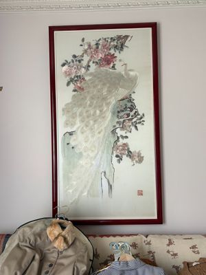 un ours en peluche assis sur un canapé, à côté d'un tableau